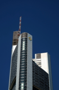 The top section of the Commerzbank Tower against a clear, dark blue sky